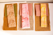 Load image into Gallery viewer, Three fabric samples including brown, green and pink with different patterns on a white background