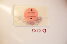 Load image into Gallery viewer, Heart-shaped stitch markers for knitting with a packaging envelope on a light background