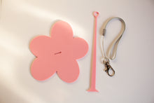 Load image into Gallery viewer, Pink flower-shaped yarn holder with pink strap, and lanyard on a light gray background