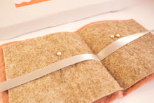 Load image into Gallery viewer, Close-up of a brown wool felt needlebook with a white ribbon, from a beginners kit
