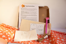 Load image into Gallery viewer, craft kit for beginners with gift tag instructions, paper, and a pink fabric pen on an orange surface.
